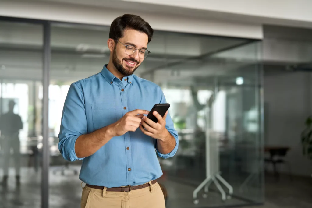 Boise business owner smiling while reviewing financial updates on mobile in modern office
