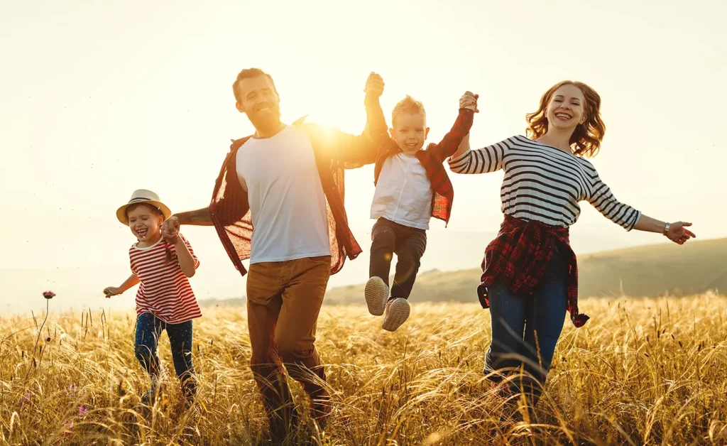 Young family running through Boise wheat field – financial freedom and clarity